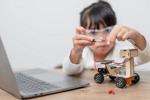 Asia students learn at home in coding robot cars and electronic board cables in STEM, STEAM, mathematics engineering science technology computer code in robotics for kids concept. photo