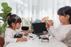 Asia students learn at home in coding robot cars and electronic board cables in STEM, STEAM, mathematics engineering science technology computer code in robotics for kids concept. photo