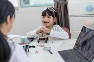 los estudiantes de asia aprenden en casa a codificar autos robot y cables de tableros electrónicos en tallo, vapor, ingeniería matemática, ciencia, tecnología, código de computadora en robótica para el concepto de niños. foto