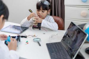 Asia students learn at home in coding robot cars and electronic board cables in STEM, STEAM, mathematics engineering science technology computer code in robotics for kids concept. photo