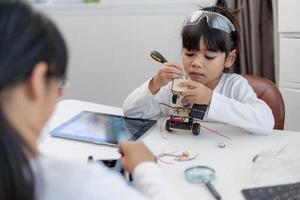 los estudiantes de asia aprenden en casa a codificar autos robot y cables de tableros electrónicos en tallo, vapor, ingeniería matemática, ciencia, tecnología, código de computadora en robótica para el concepto de niños. foto