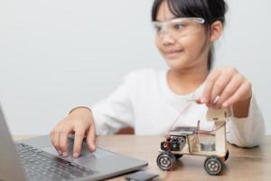 Asia students learn at home in coding robot cars and electronic board cables in STEM, STEAM, mathematics engineering science technology computer code in robotics for kids concept. photo