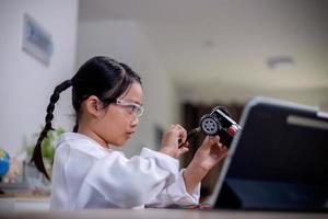 Asian students learn at home by coding robot cars and electronic board cables in STEM, STEAM, mathematics engineering science technology computer code in robotics for kids' concepts. photo