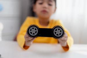 los estudiantes de asia aprenden en casa a codificar autos robot y cables de tableros electrónicos en tallo, vapor, ingeniería matemática, ciencia, tecnología, código de computadora en robótica para el concepto de niños. foto