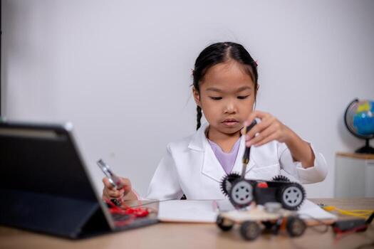 Asian students learn at home by coding robot cars and electronic board cables in STEM, STEAM, mathematics engineering science technology computer code in robotics for kids' concepts. photo