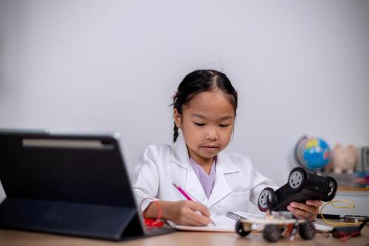 Asian students learn at home by coding robot cars and electronic board cables in STEM, STEAM, mathematics engineering science technology computer code in robotics for kids' concepts. photo