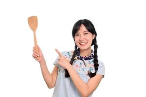 retrato de una hermosa joven asiática sonriendo con vestido de mezclilla con espátula sobre fondo blanco foto