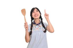 retrato de una hermosa joven asiática sonriendo con vestido de mezclilla con espátula sobre fondo blanco foto