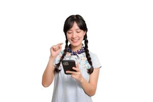 Portrait of happy beautiful young asian woman in denim dress using a smartphone on white background. studio shot photo