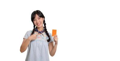Portrait of beautiful happy young asian woman in denim dress holding credit card on white background