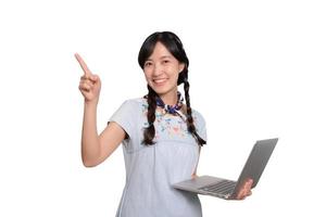 retrato de una hermosa y feliz joven mujer asiática independiente vestida de mezclilla usando un trabajo portátil con éxito en el fondo blanco foto