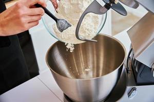 Woman cooking at kitchen and using kitchen machine photo