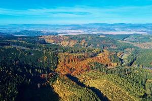 Aerial view of mountains covered with autumn forest photo