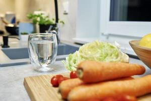 Glass of clean water and vegetables photo