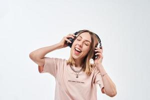 Happy smiling woman with headphones listening music and dancing photo
