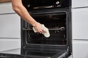 Woman open electric oven door photo