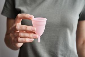 mujer sostiene copa menstrual en las manos foto