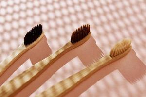 Reusable bamboo toothbrushes on pink background. Zero waste photo