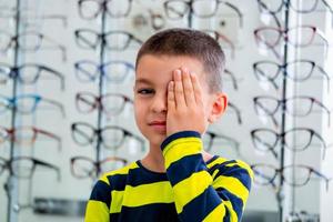 niño pequeño que tiene un examen ocular en la oficina del oftalmólogo foto