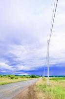 green field landscape with blue sky and stormy clouds. photo