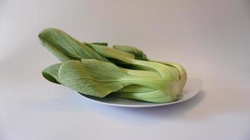 Bok choy vegetables on a plate on a white background. photo