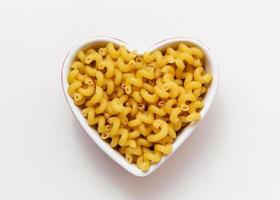 Raw pasta cavatappi in heart bowl. photo