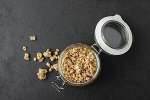 Granola in jar on dark table. photo