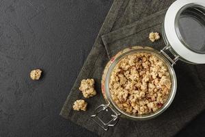 Granola in jar on dark napkin. photo