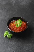 Salmon caviar with parsley in a bowl photo