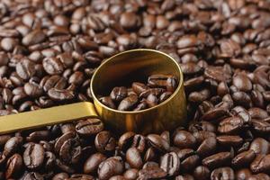 granos de café en cuchara de oro. foto