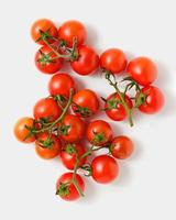 Cherry tomatoes on branches on white background. photo