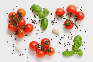 Cherry tomatoes on branches with green basil and garlic. photo