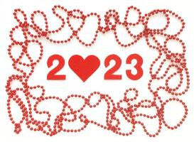 Red felt numbers 2023 on white background. Zero in the shape of a heart. Red beads around. Flat lay for Valentines Day. photo