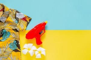 Colorful shirt with water gun on blue and yellow background for Songkran Festival celebration in Thailand for summer time on April. photo