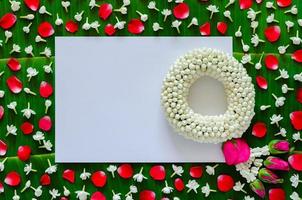 White blank paper with jasmine garland and flowers on banana leaf background for Songkran festival. photo