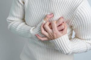 woman hand holding chest ache. Heart disease, angina disease and symptom heart attack disease Cardiovascular, Atherosclerosis, Hypertensive world Heart day and health concept photo