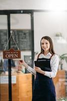 startup exitosa propietaria de una pequeña empresa sme mujer de pie con tableta en café restaurante. dueña de una cafetería barista. foto