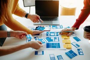 UX developer and ui designer brainstorming about mobile app interface wireframe design with customer breif and color code at modern office. photo