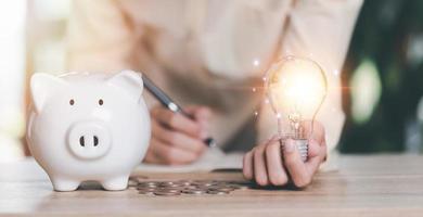 financial concept and saving money,investment savings,Planning savings for the future,retirement fund,financial preparation,future risk management,Man holding a light bulb and piggy bank on the table photo