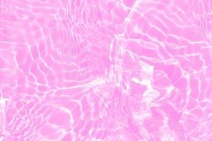 Defocus blurred transparent pink colored clear calm water surface texture with splashes and bubbles. Trendy abstract nature background. Water waves in sunlight with copy space. Pink water shine photo