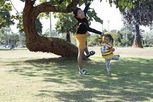 familia asiática divirtiéndose en el jardín madre e hija divirtiéndose juntas. foto