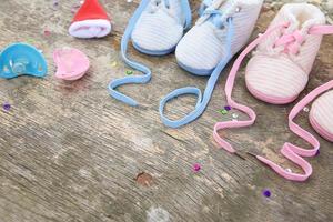 2023 new year written laces of children's shoes and pacifier on old wooden background. Space for text. photo