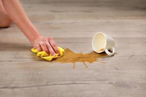 A cup of coffee fell on laminate, coffee spilled on floor. photo