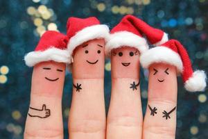 Fingers art of friends celebrates Christmas. The concept of a group of people laughing in new year hats. photo