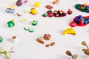 pan, baguette, pretzels y otros alimentos de arcilla polimérica sobre un fondo claro. ocio infantil. foto