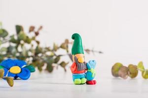 Gnome from polymer clay on a light background. Handmade decor photo