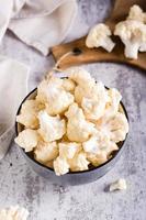 Fresh raw cauliflower in a bowl on the table. Natural antioxidant. Vertical view photo