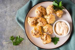 Cauliflower barbecue wings and sauce on a plate on the table. Vegetarian food. Top view. Closeup photo