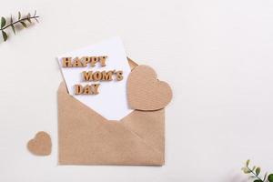 Happy mother's day. Envelope with a sheet, letters and hearts on a light background. photo