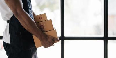 Emprendedor de un joven asiático que trabaja con una caja para empaquetar pedidos de compras en línea en casa para negocios en línea y compras en línea. foto